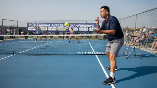 Tournament referee observing line calls during a 2026 USAP sanctioned pickleball match